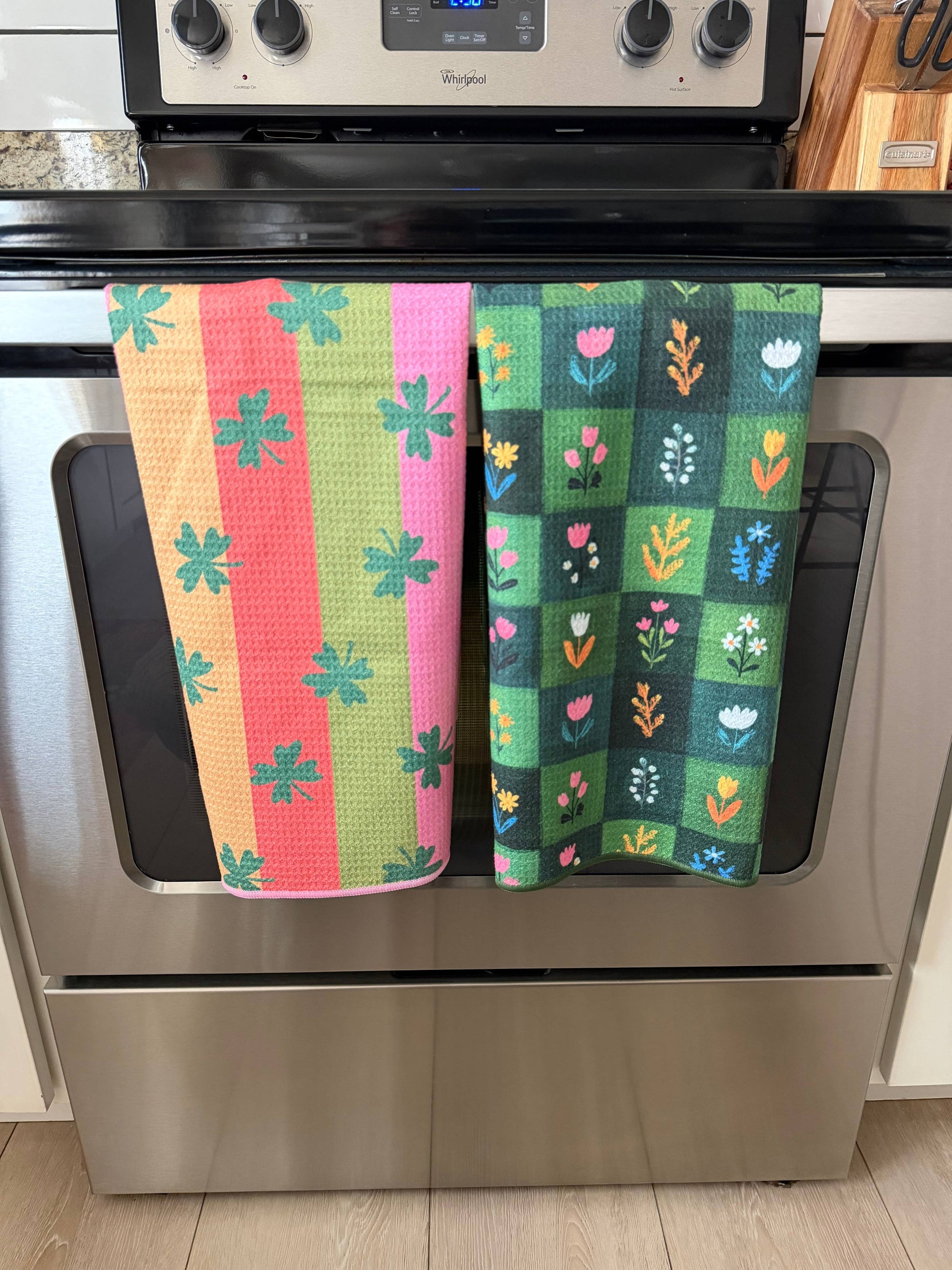 Colorful patterned towels hanging on a stove handle