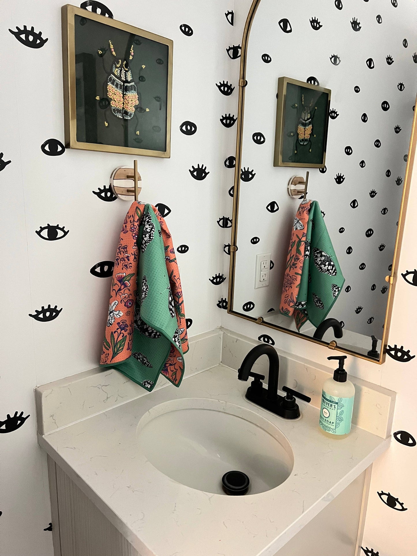 Bathroom with sink, mirror, and decorative wall patterns