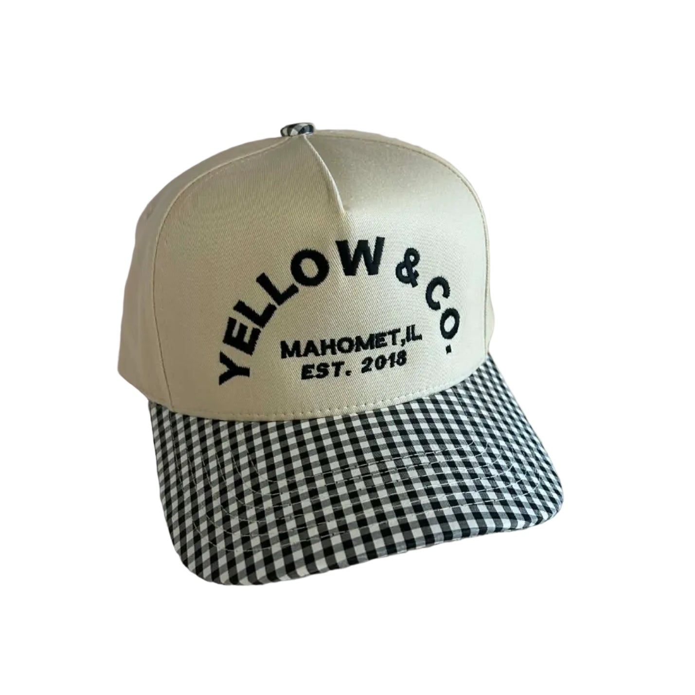 Beige cap with black checkered brim and 'Yellow & Co' branding on a light wooden surface.