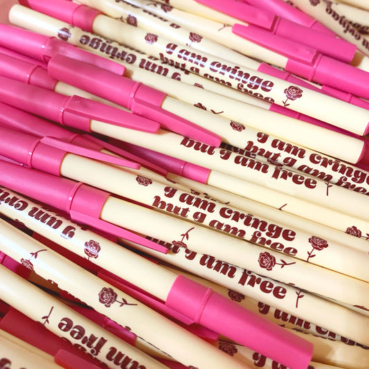 Stack of pens with pink caps and white bodies featuring text and floral designs.