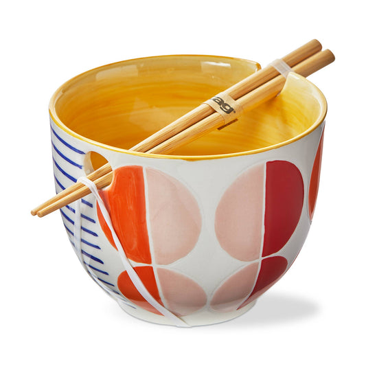 Ceramic noodle bowl with colorful circles pattern, yellow inside and wooden chopsticks on a white background