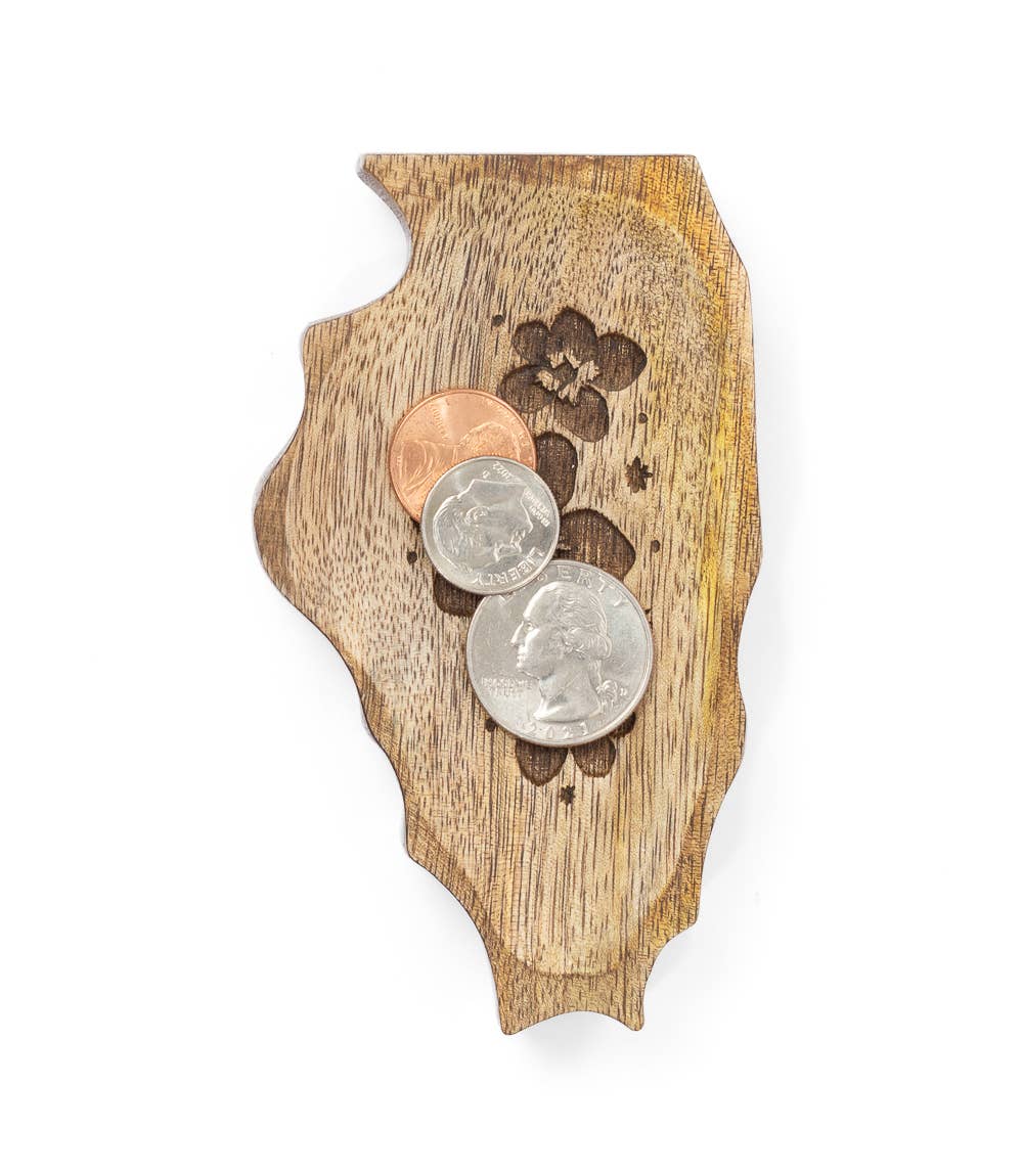 Wooden coaster with engraved design holding coins on a white background