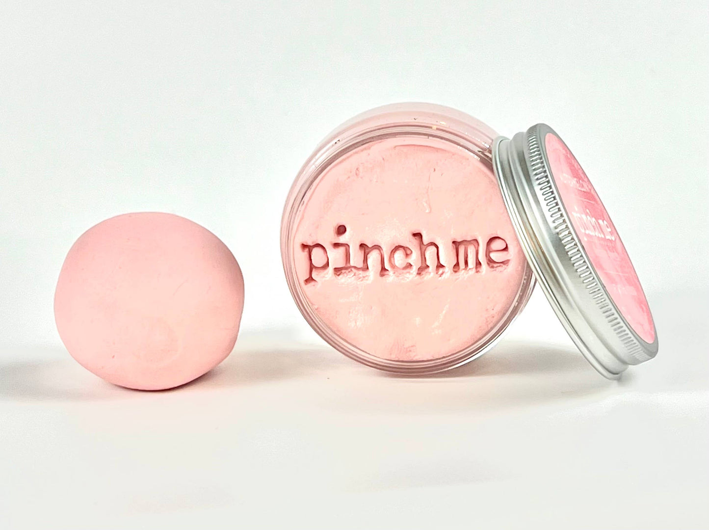 Pink therapy dough with 'pinch me' text on a white background