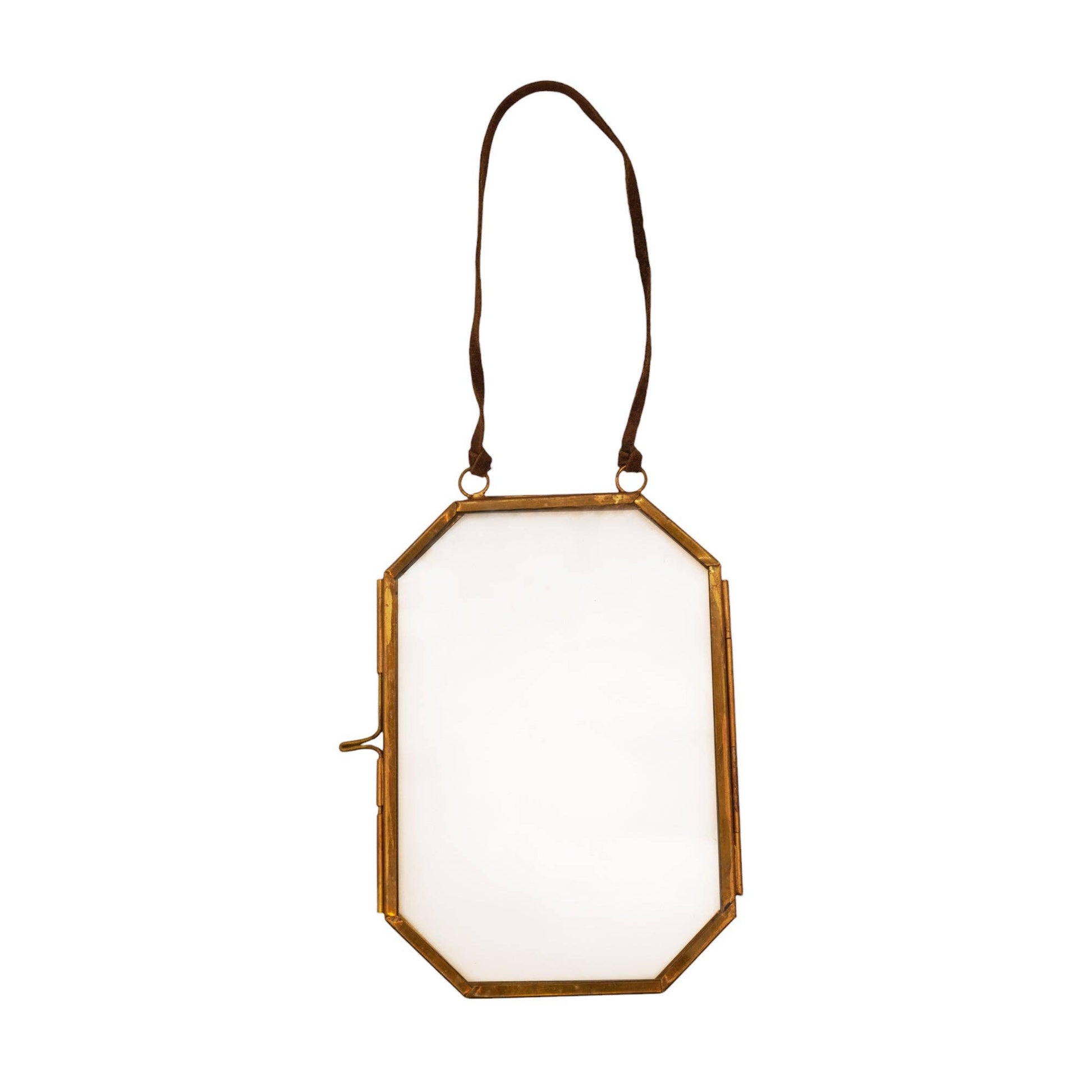 Decorative wall mirror with gold frame and white glass on a white background