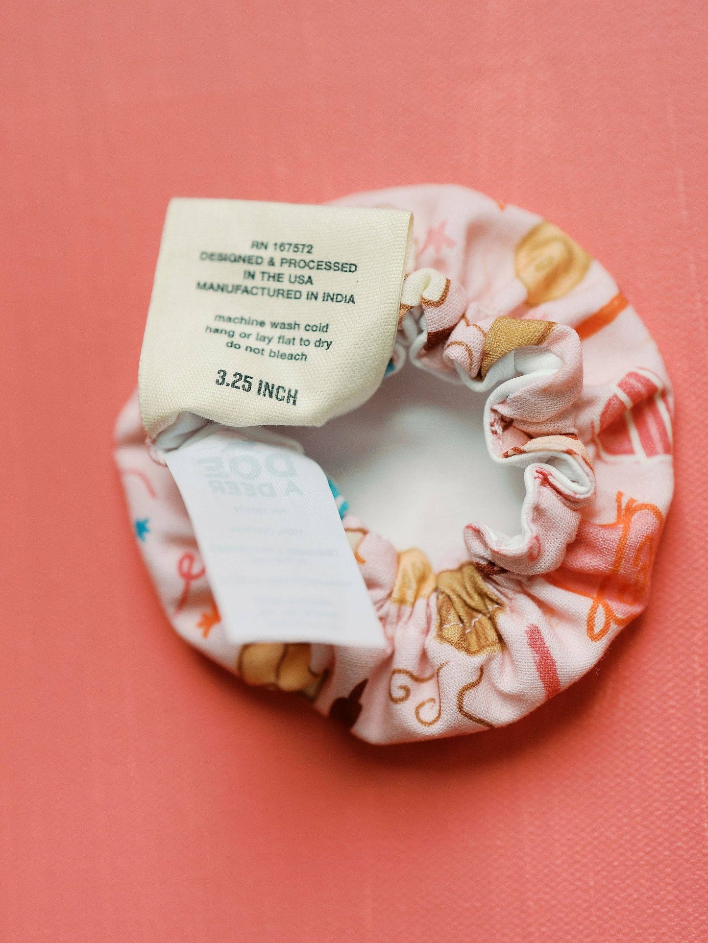 Fabric scrunchie with label on a pink background