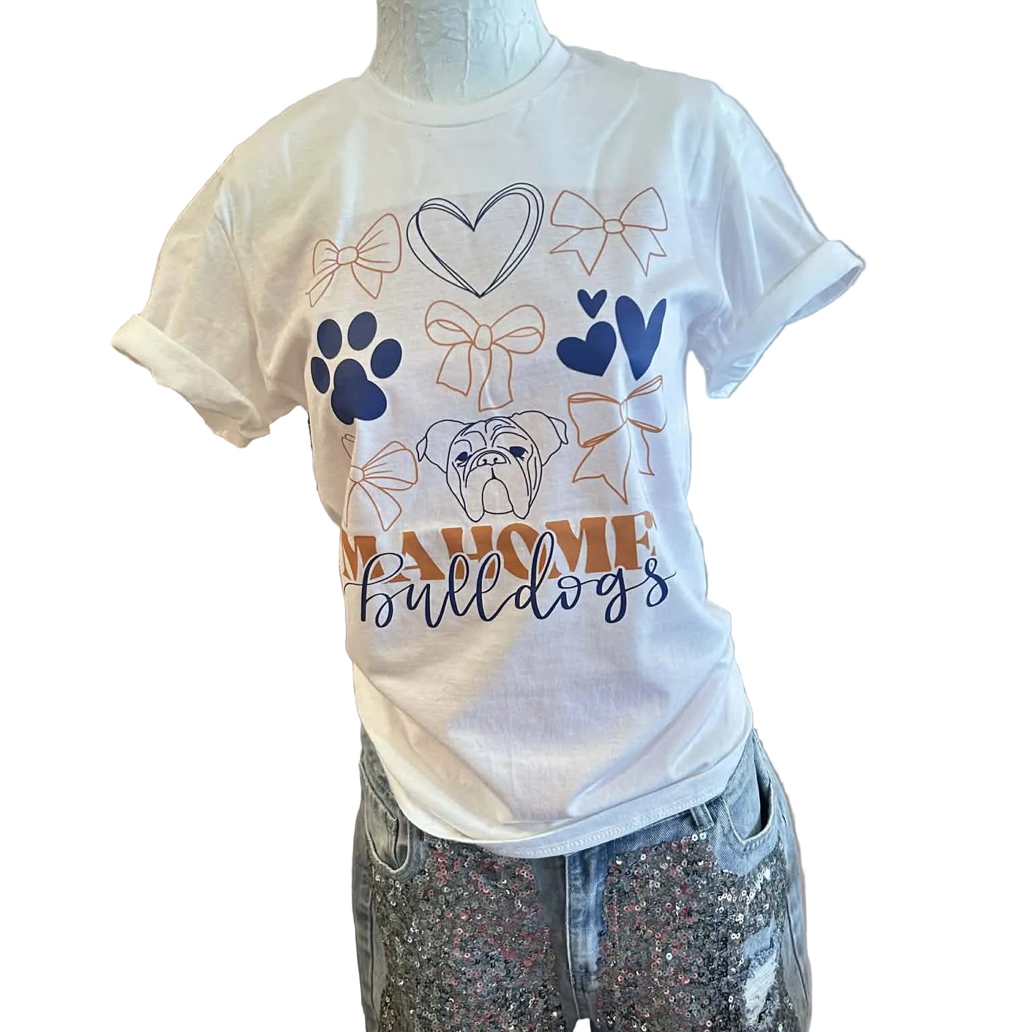 White t-shirt with bows, hearts, paw prints and a bulldog graphic with Mahomet Bulldogs text on a mannequin against a white wall.