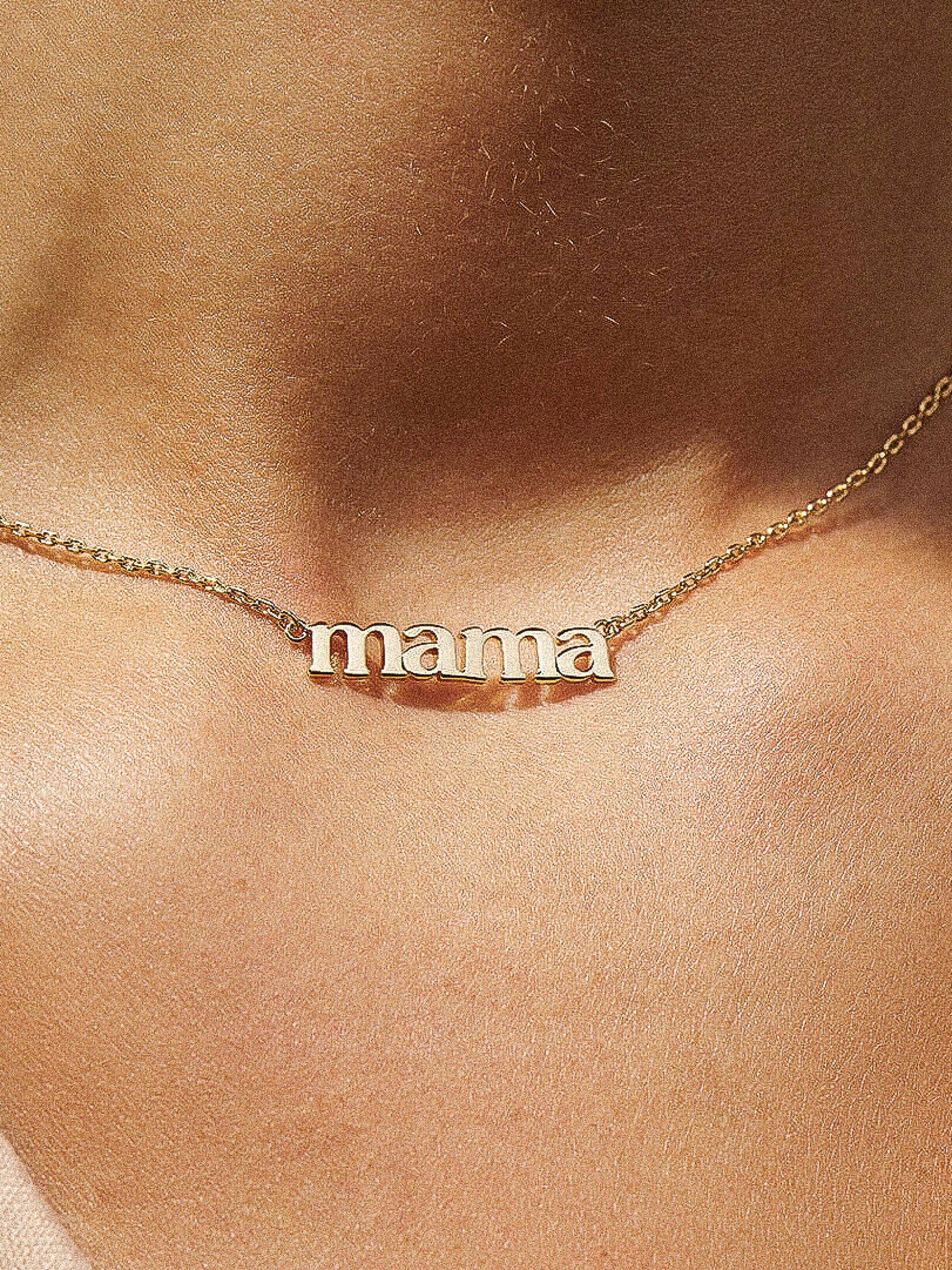 Gold 'mama' necklace on a person's neck