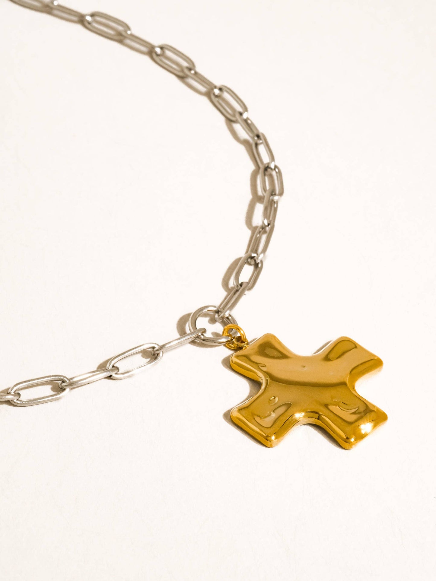 Gold star charm on a silver chain against a white background