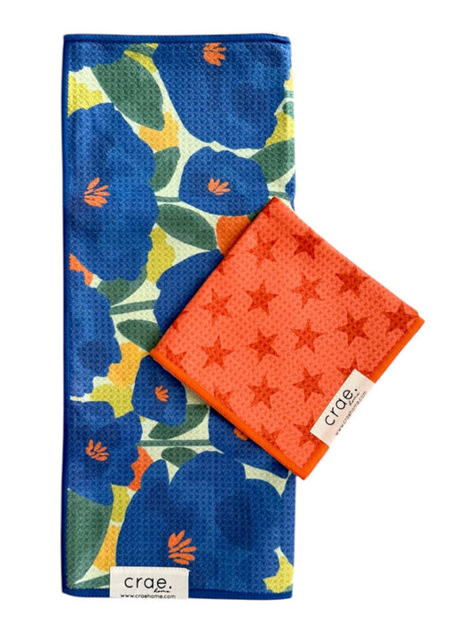 Two patterned cloths, one blue with floral design and one orange with star pattern, on a white background.