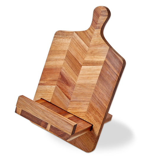 A wooden cookbook stand that resembles a cheese board. Wooden pieces join together to create a cantilevered stand. One a white background