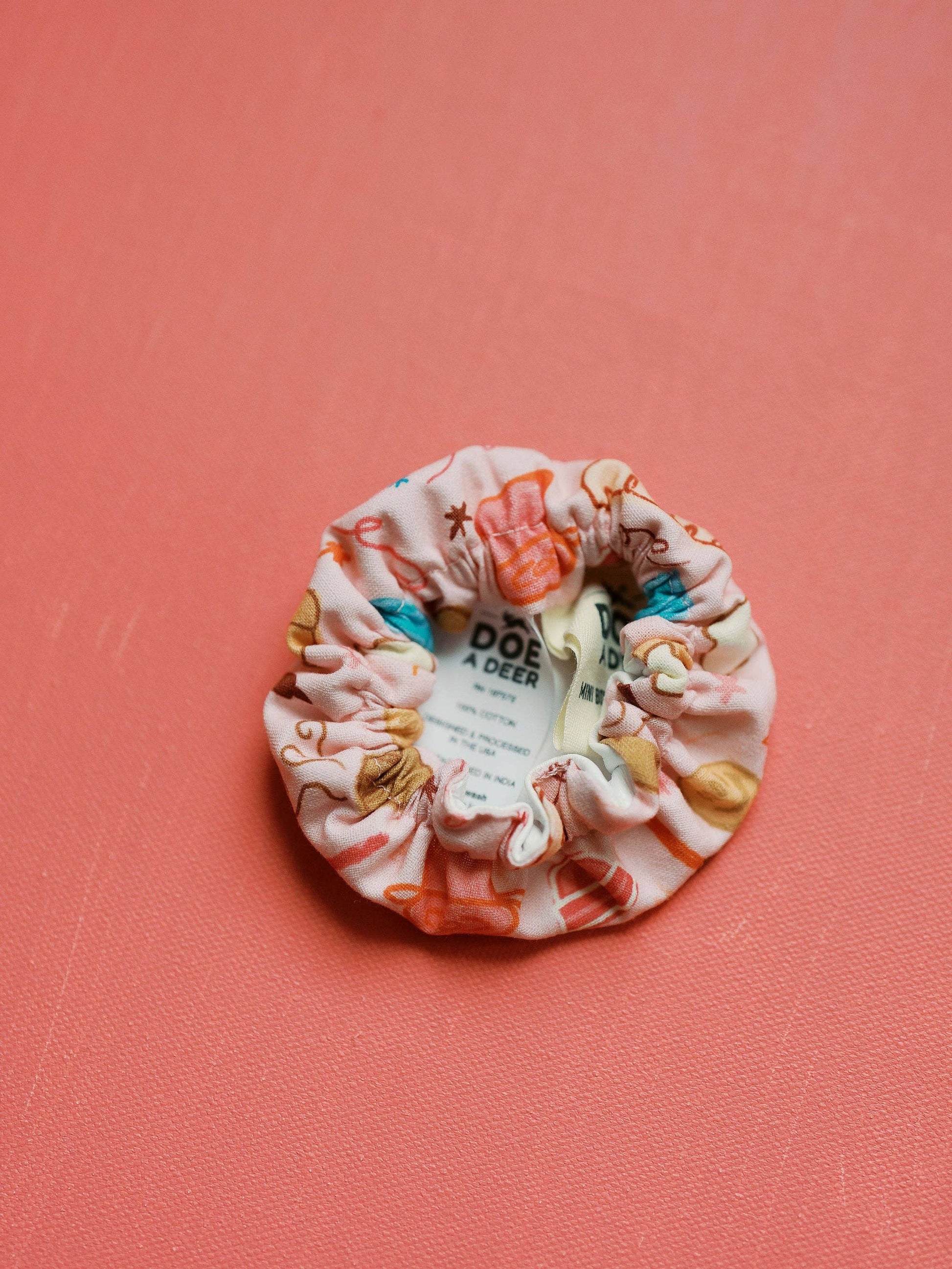 Decorative scrunchie with a label on a pink background