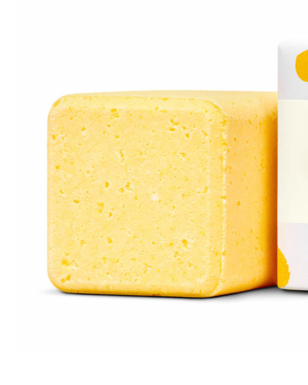 Yellow bath bomb with a white label on a white background