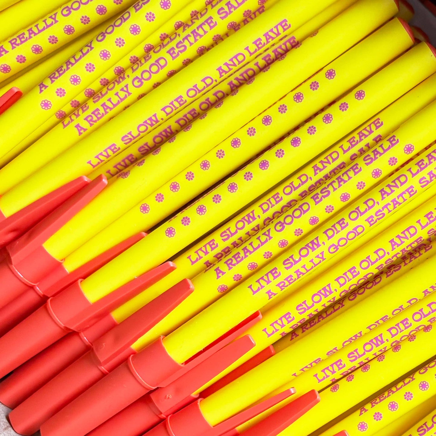 Stack of yellow and red pens with text on a white background