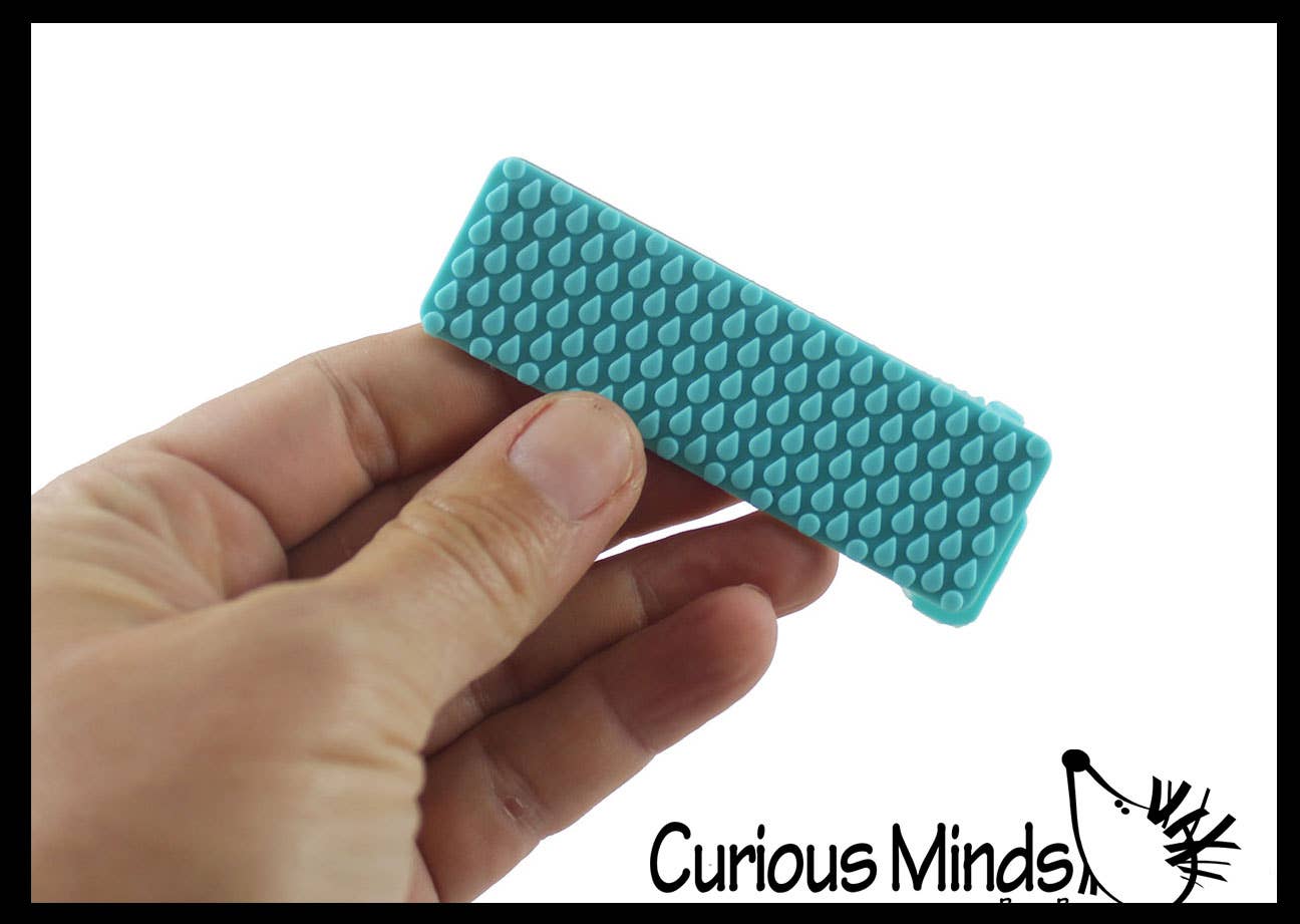 Hand holding a blue textured rectangular sprip with 'Curious Minds' branding.