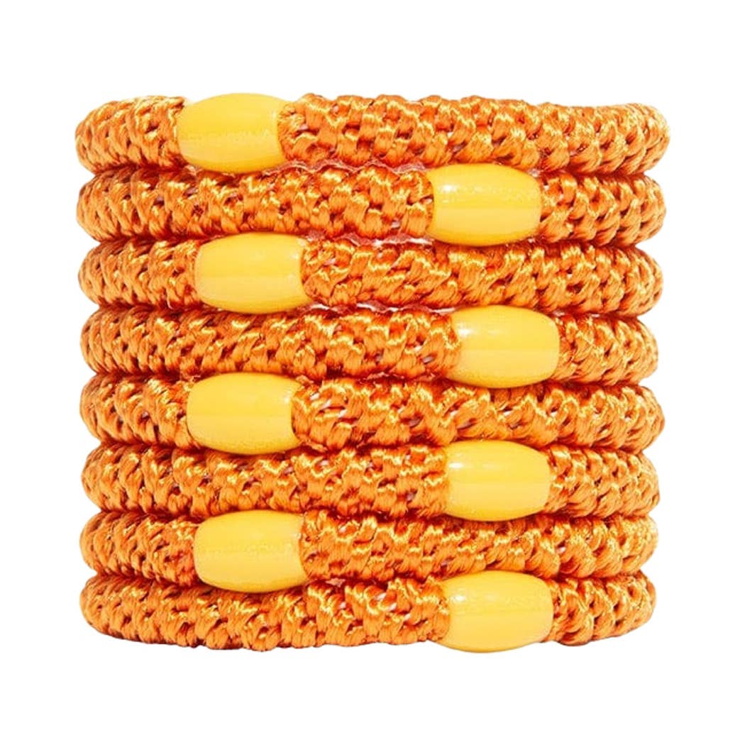 A stack of eight braided elastic wristbands in orange and yellow, arranged vertically on a plain white background.