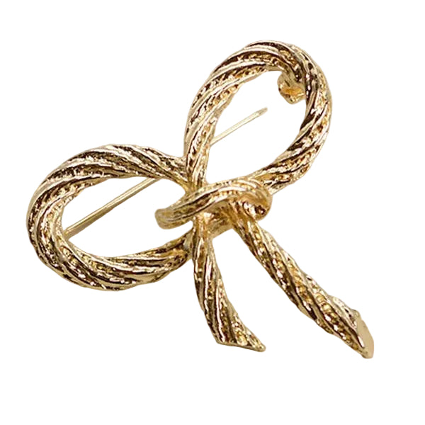 Gold bow-shaped brooch with rope like texture on a white background