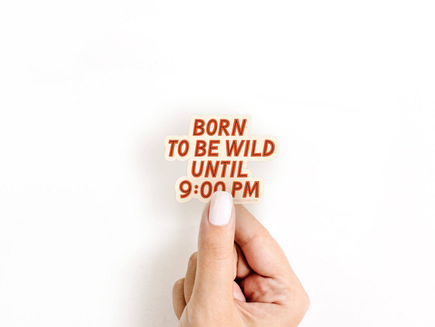 Hand holding a small sign with 'Born to be wild until 9:00 PM' text on a white background