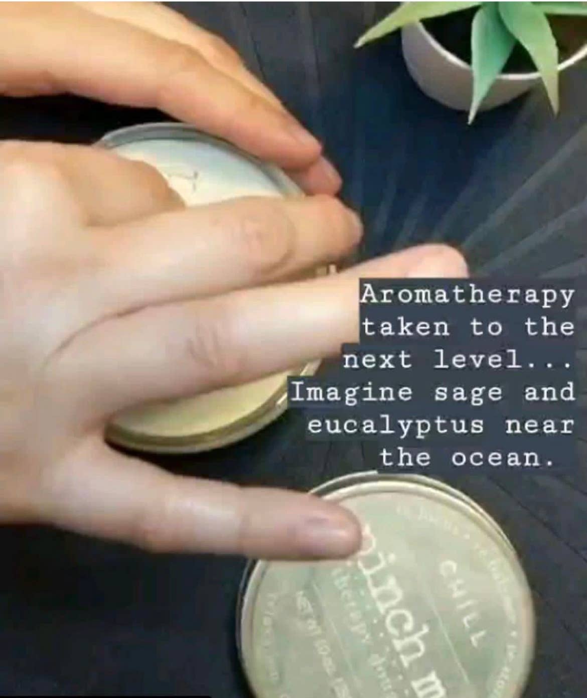 Person holding a container with text about aromatherapy and product branding.