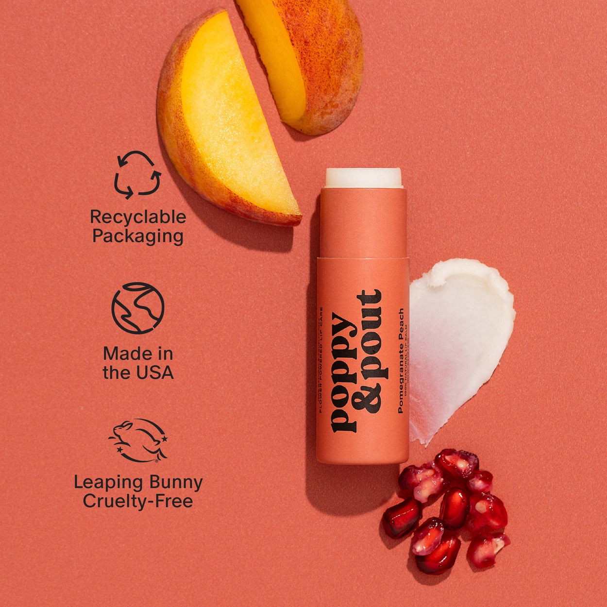 Poppy & Pout lip balm with pomegranate pieces and a peach slice on a pink background