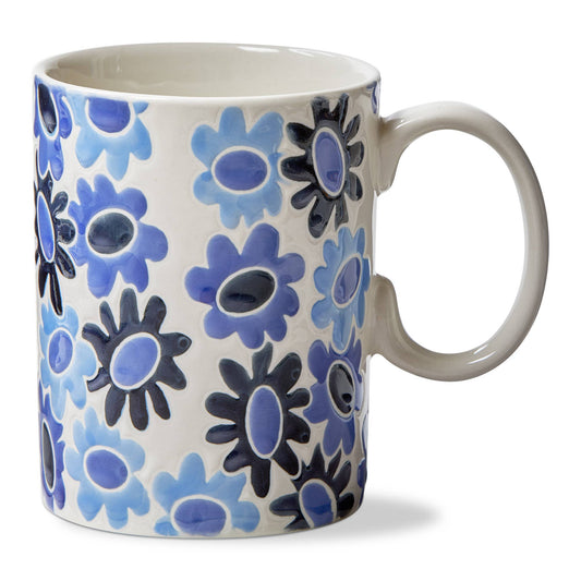 A white glossy mug with blue 'mod' styled, petaled flowers in 3 shades of blue. The handle of the mug is white,as is the interior of the mug. On a white background.