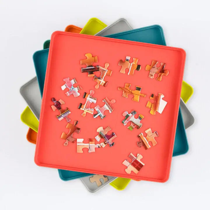 Colorful puzzle pieces on a red tray with a white background