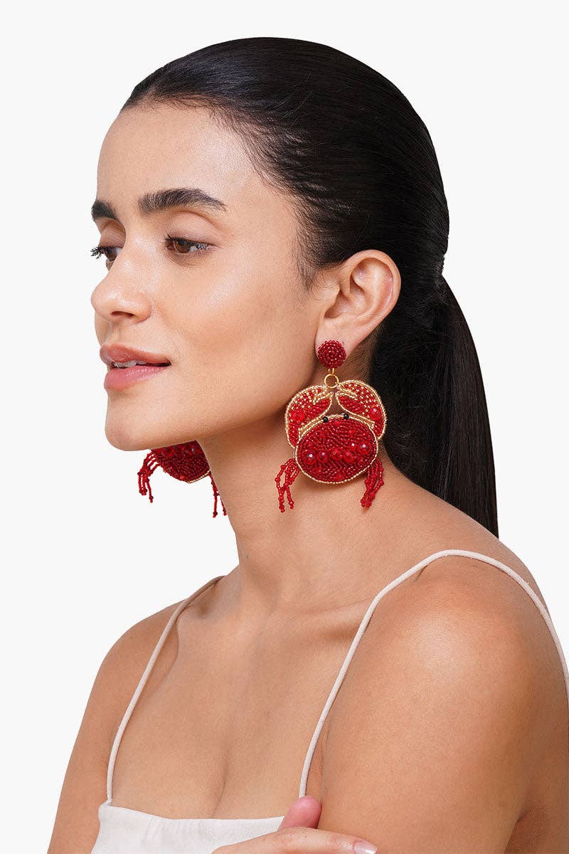 Woman wearing red beaded earrings against a white background