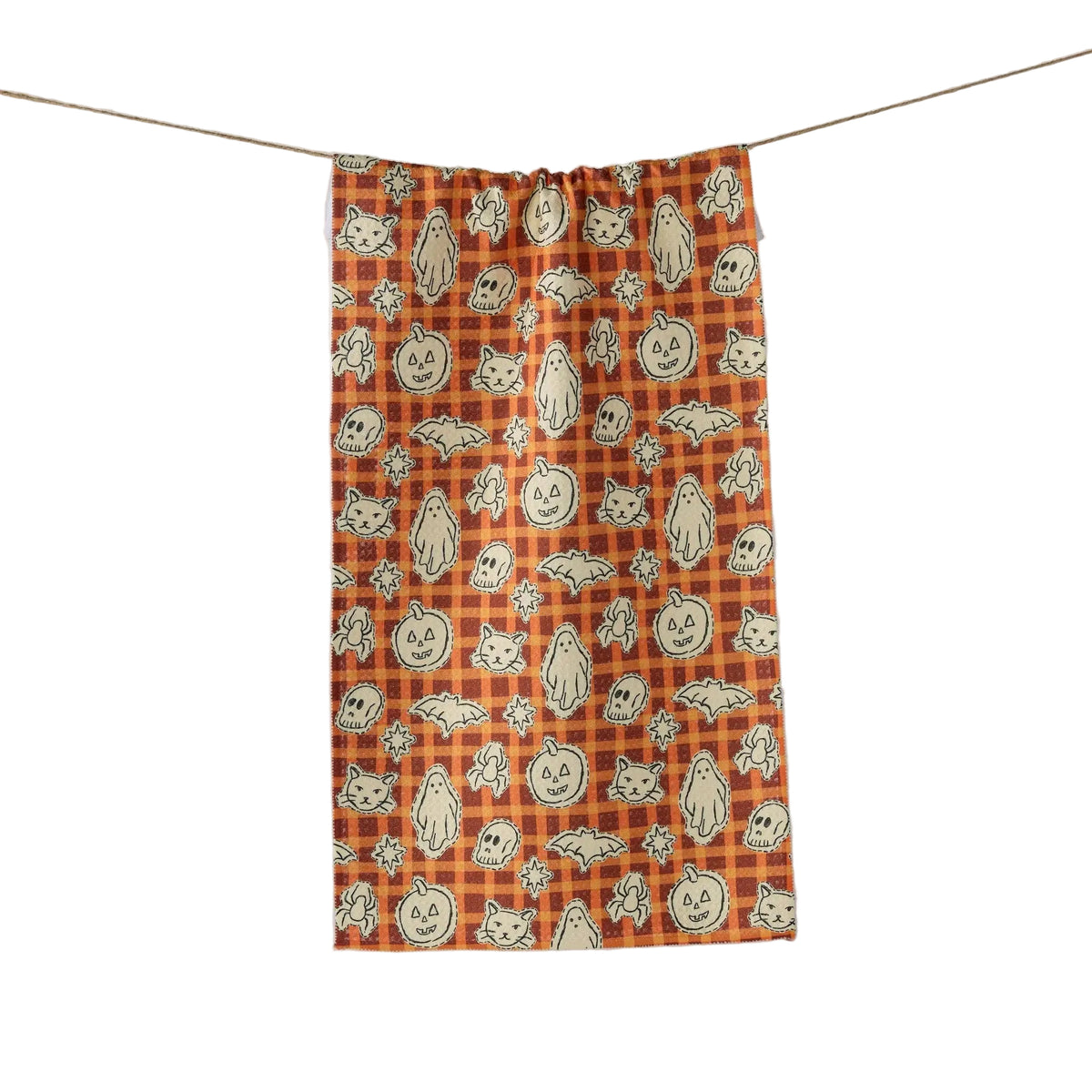 An orange and black plaid kitchen towel with a repeating pattern of cartoon jack-o'-lanterns, ghosts, cats, bats, spiders and skulls hanging from a thin string against a white background