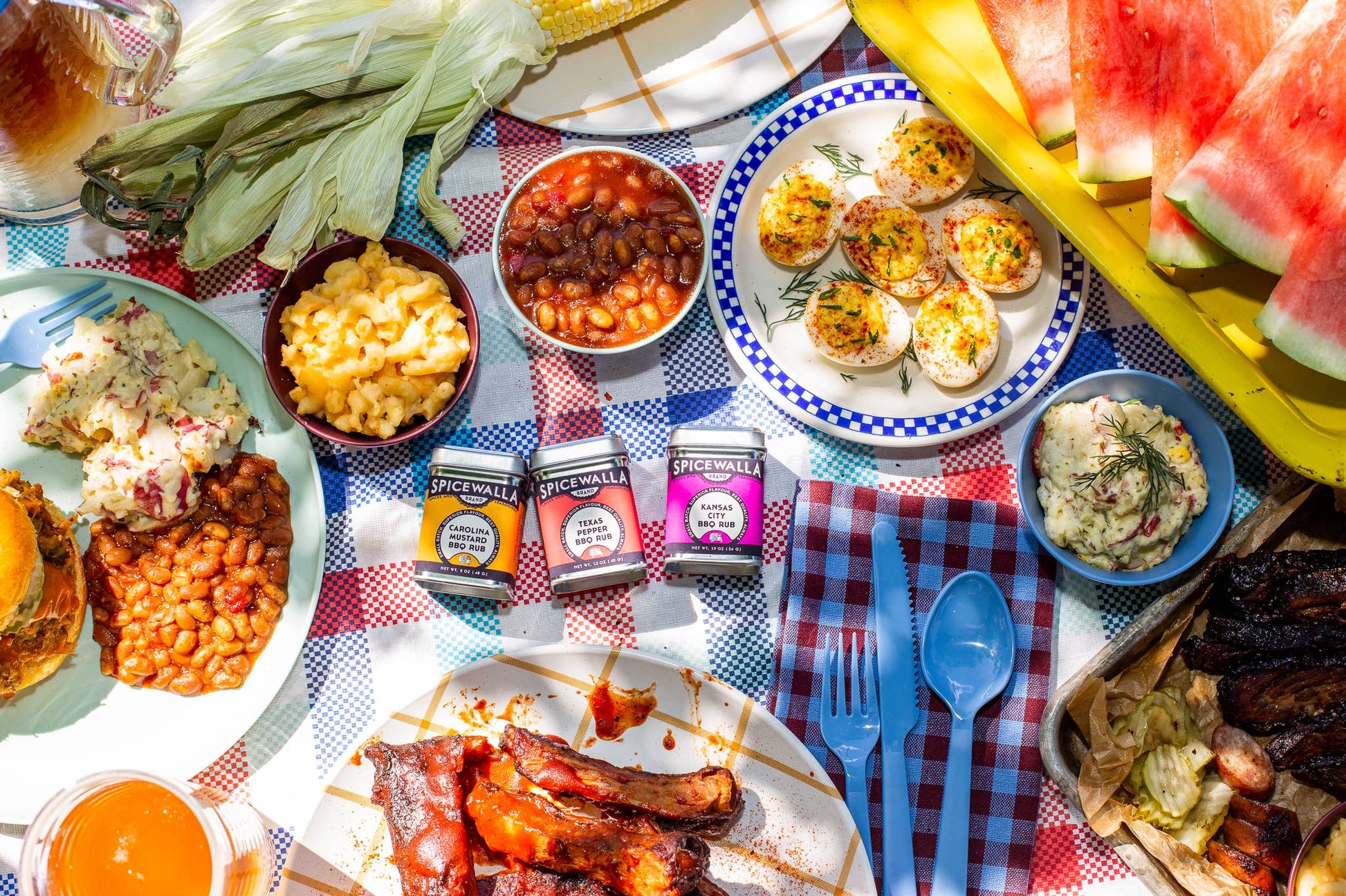 Outdoor picnic with various food items on a checkered tablecloth