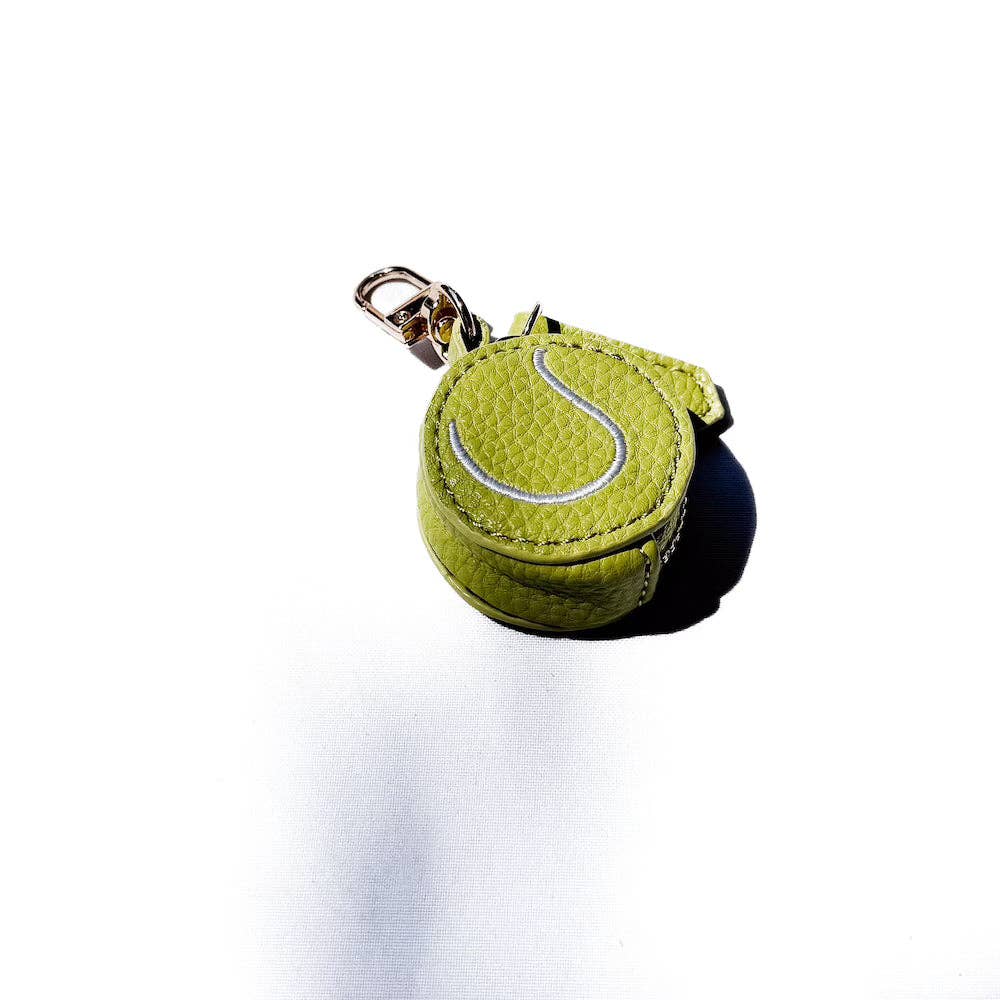 Green tennis ball-shaped keychain with a silver tag on a white background
