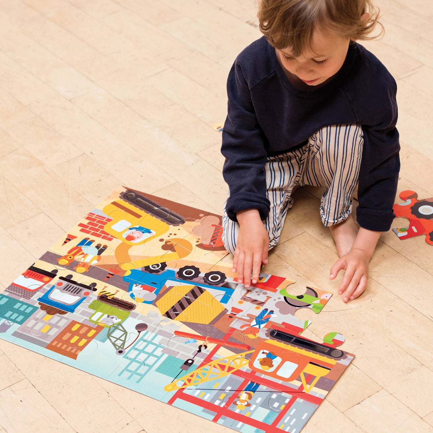 Child playing with a colorful puzzle on a wooden floor