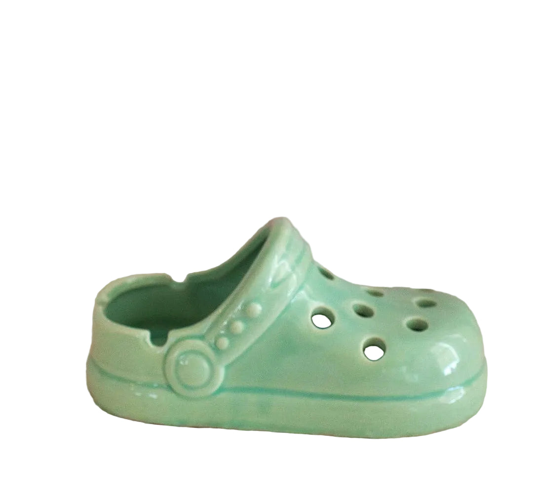 Light green ceramic croc clog on a white background