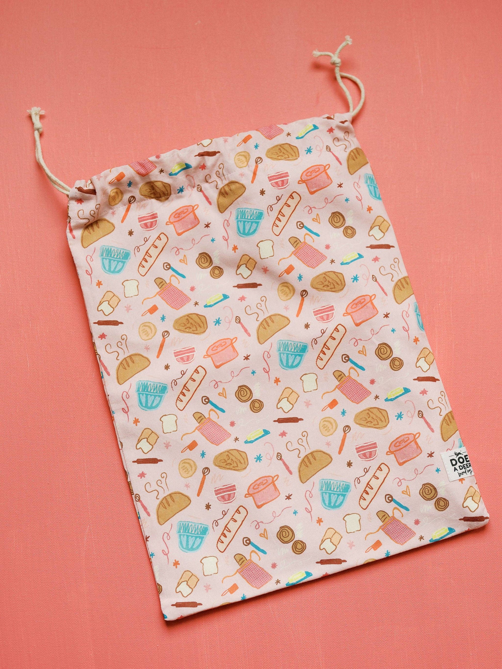 Drawstring bag with food-themed pattern on a pink background