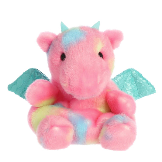 Plush toy dragon with pink body, blue wings, and multicolored accents on a white background