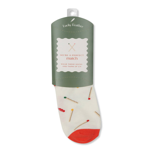 Sock with red sole and matches pattern on a white background, with a band that reads "We're a perfect match" 