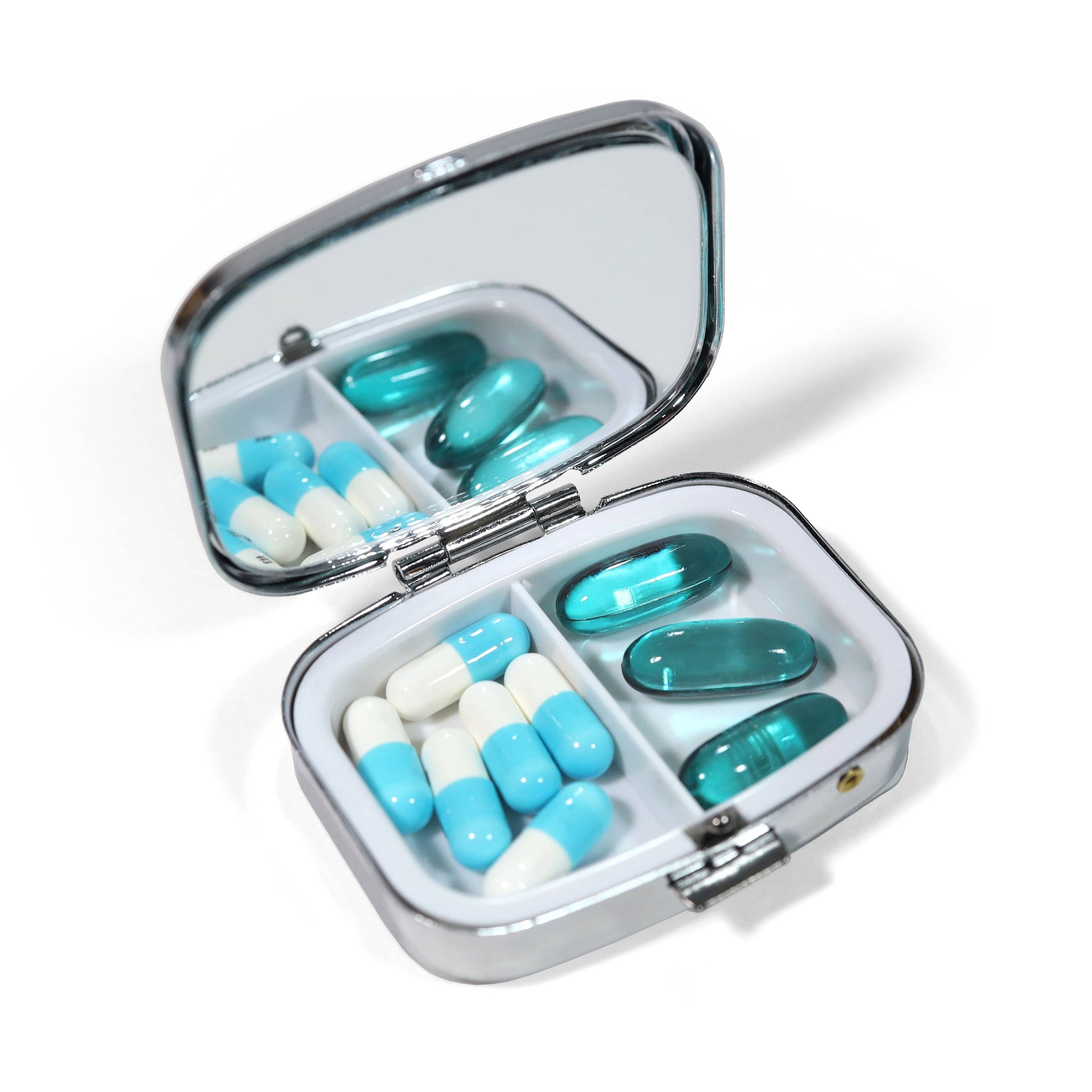 Open pill organizer with blue and white pills on a white background
