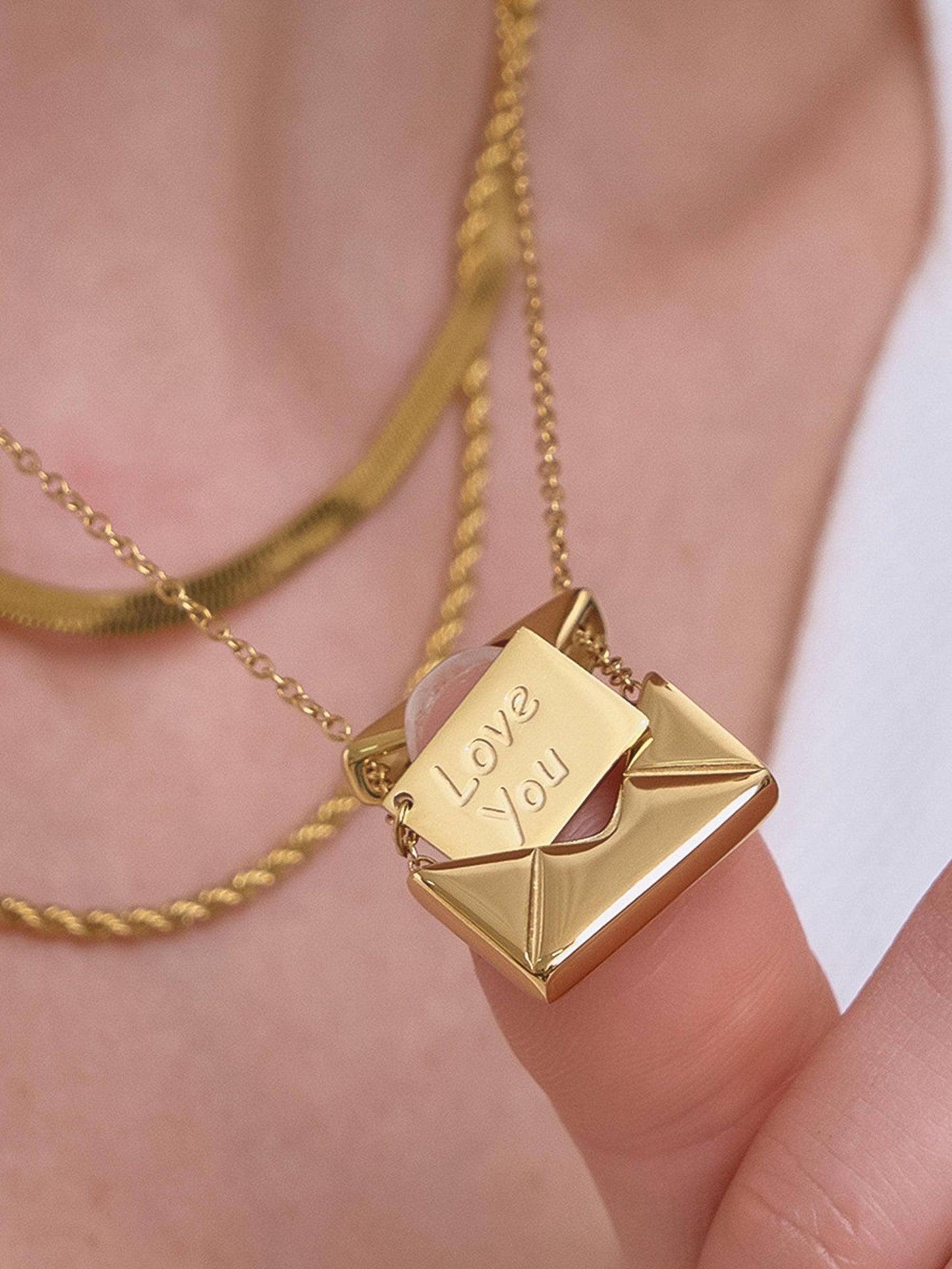 Gold necklace with 'Love You' pendant on a blurred background