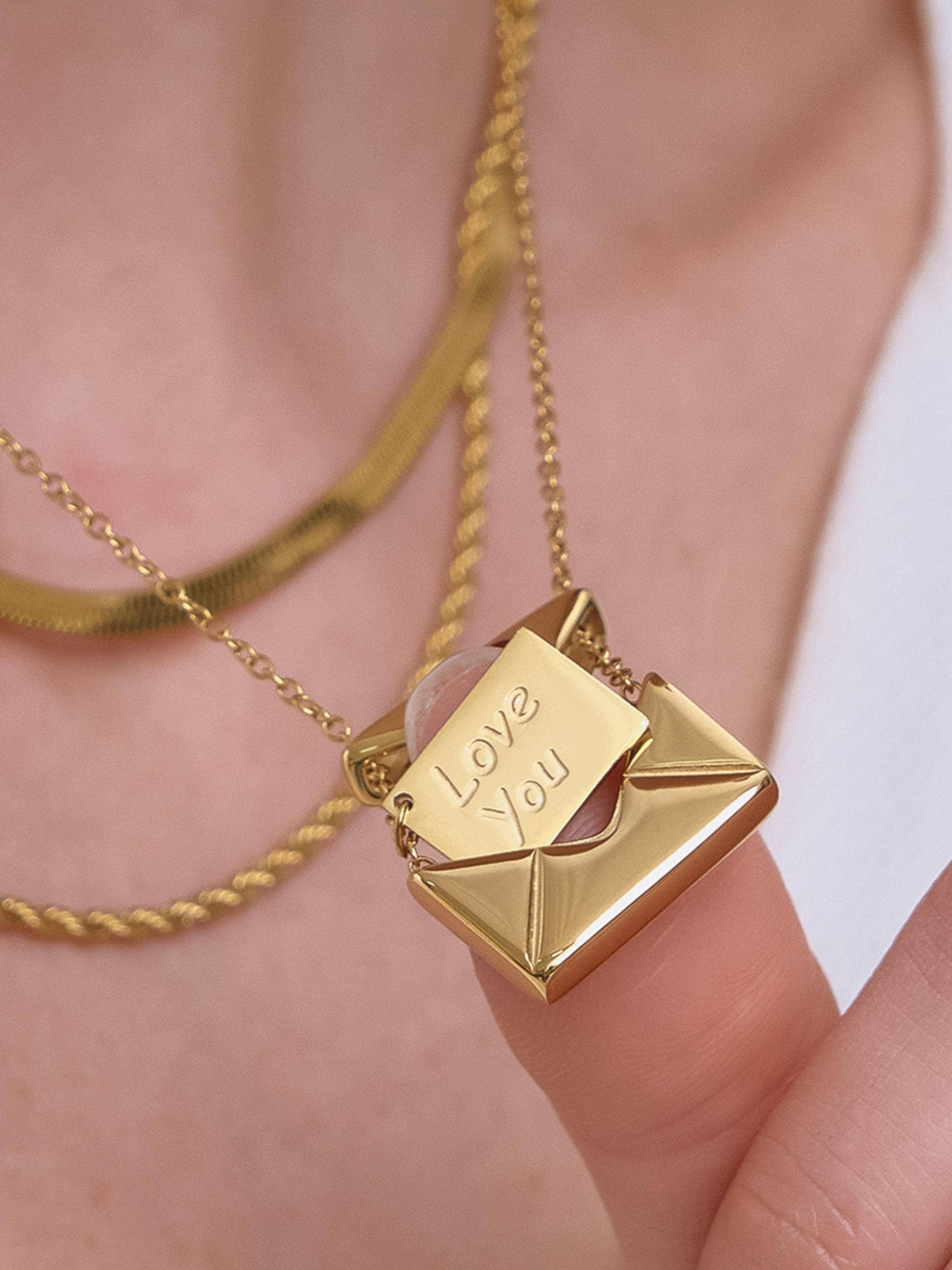 Gold necklace with 'Love You' pendant on a blurred background