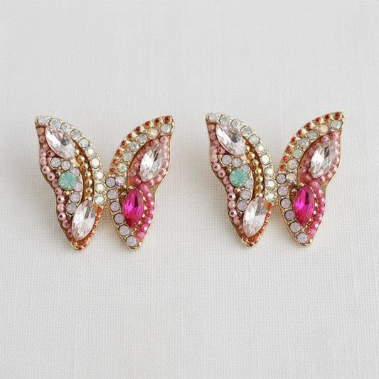 Butterfly-shaped earrings with gemstones on a light gray background