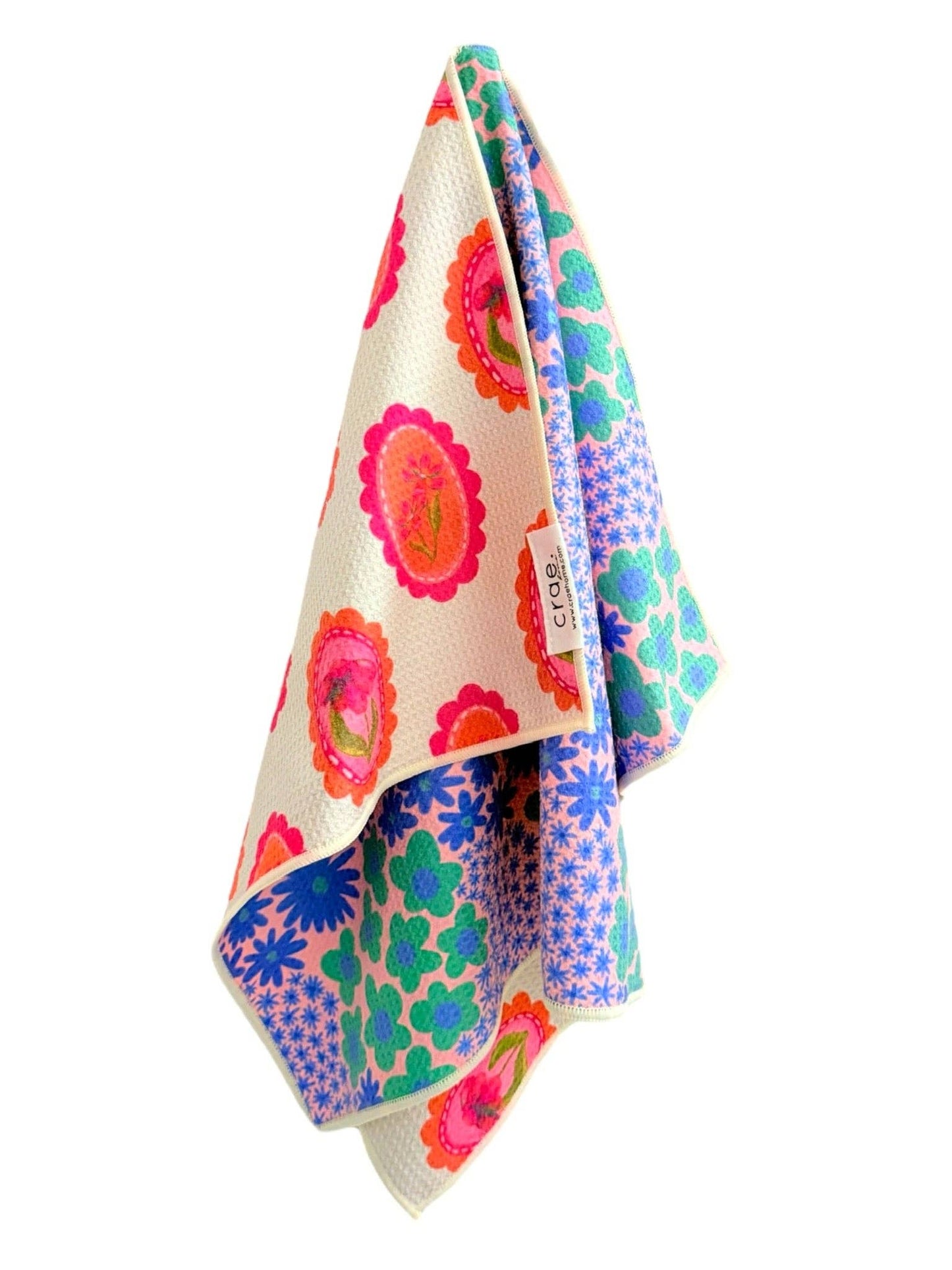 Colorful floral patterned towel with brand name on a white background