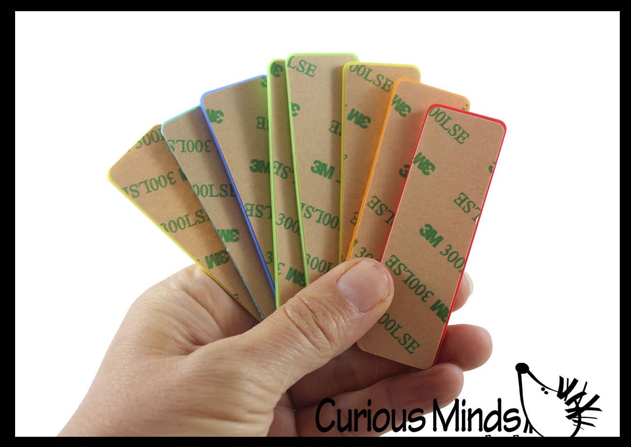 Hand holding a set of textured strips with 3M tapes on back with 'Curious Minds' branding.