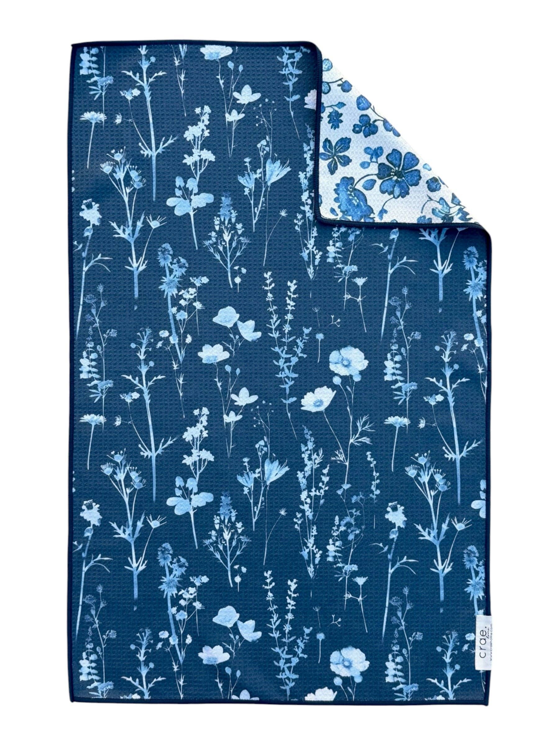 Floral patterned fabric with blue and white flowers on a dark blue background