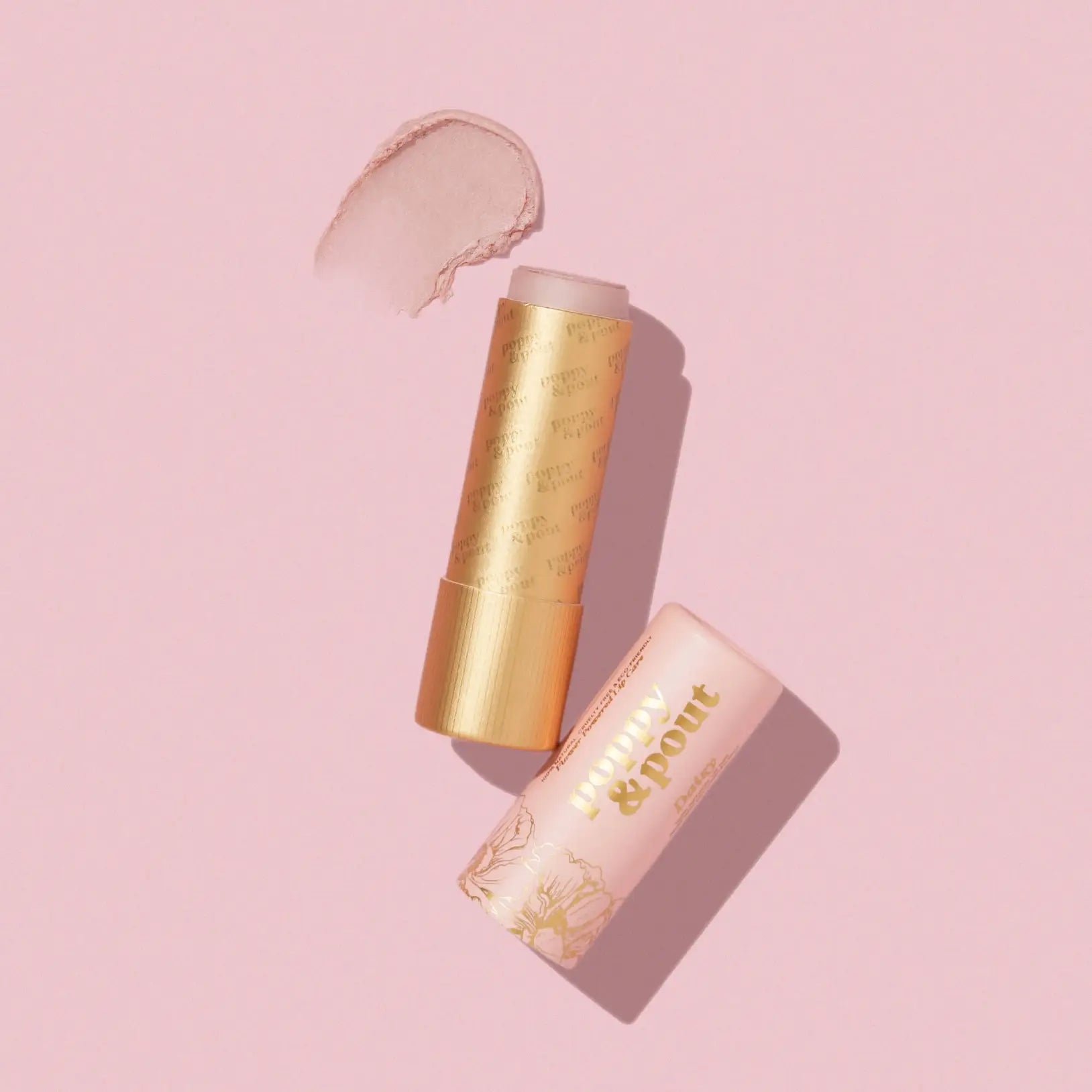 Two cosmetic sticks with a swatch on a pink background