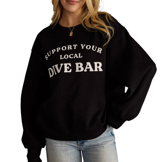 Woman wearing a black sweatshirt with 'Support Your Local Dive Bar' text on a white background