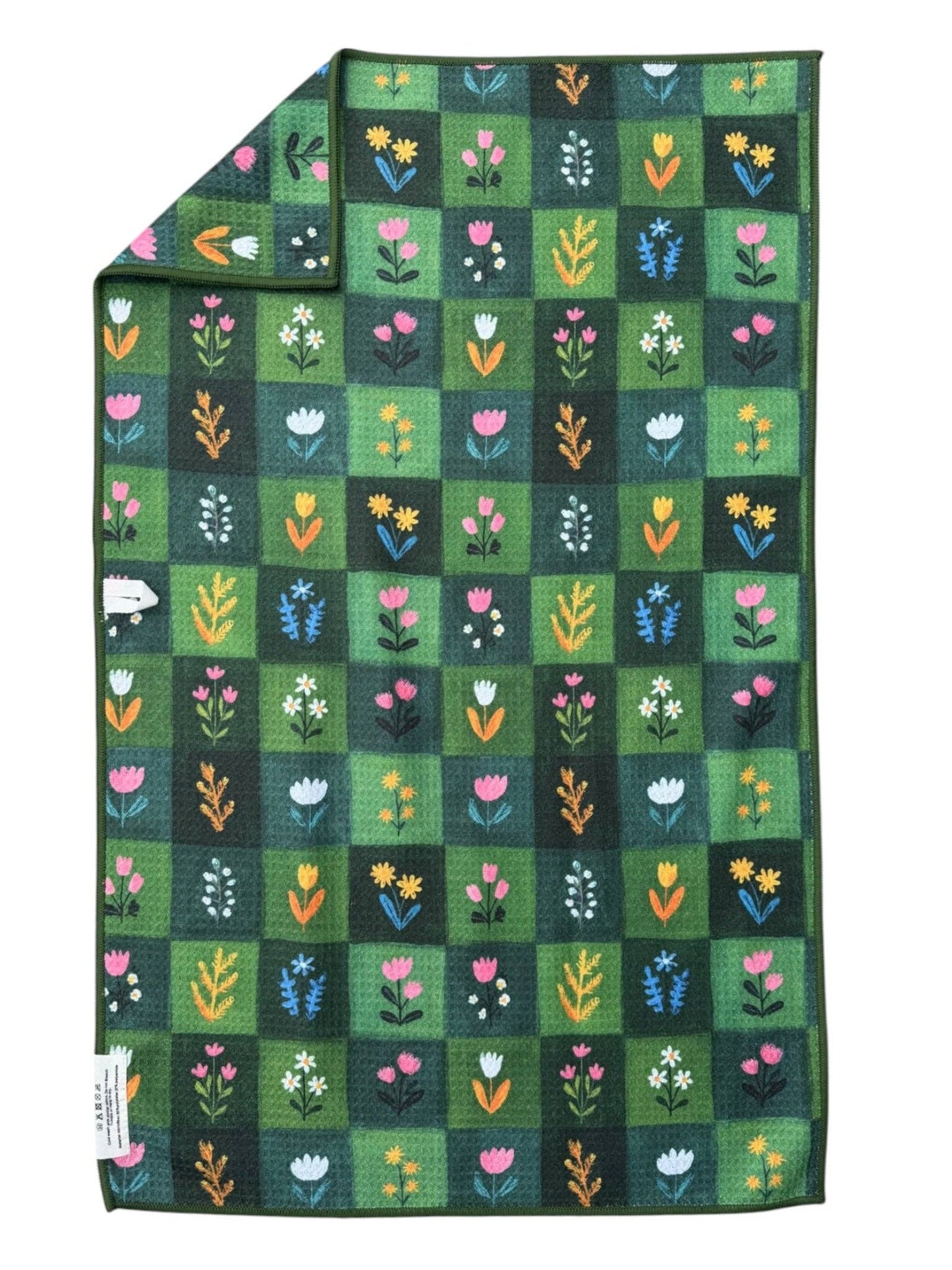 Dark green checkered tea towel with flowers in each square on a white background