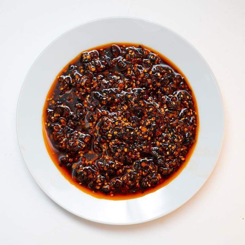 Dark red sauce on a white plate with a white background
