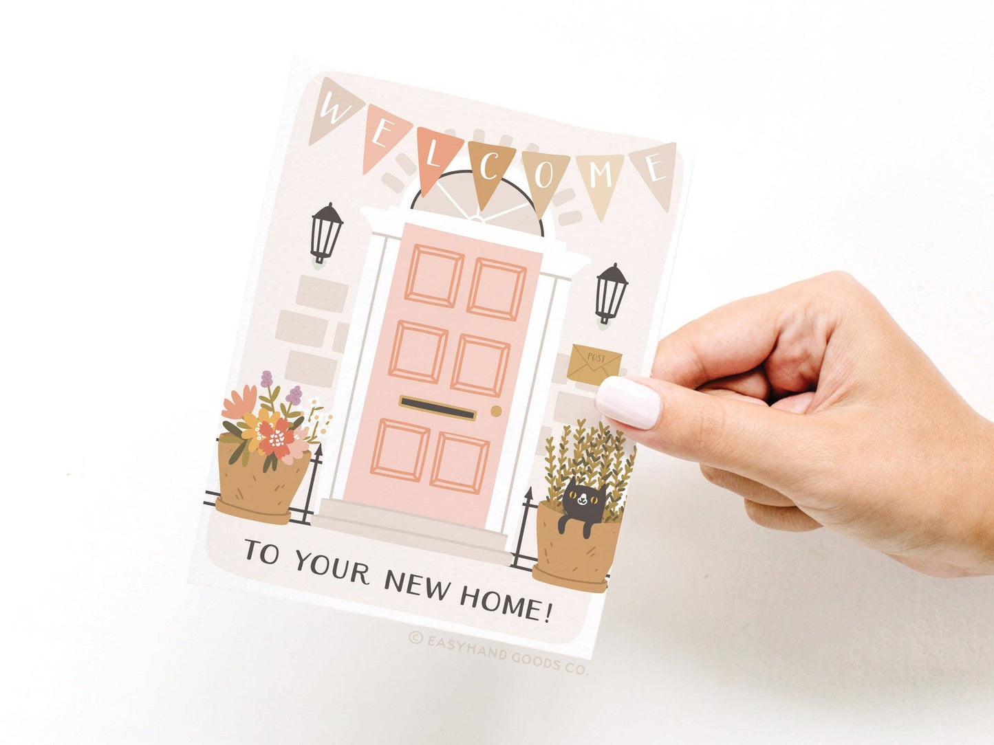 Hand holding a card with a new home illustration and text on a white background