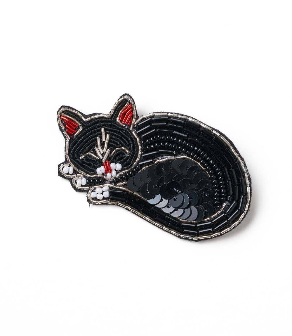 Black cat-shaped pin with sequins on a white background