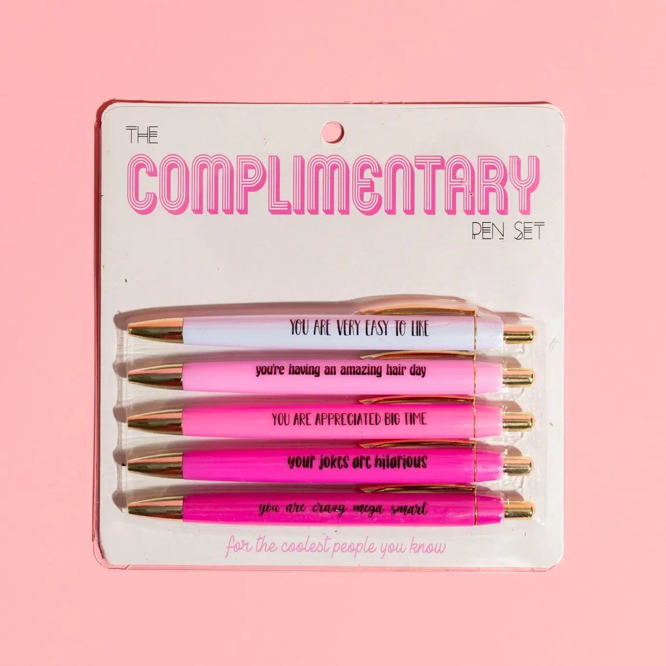 Set of pens in packaging with humorous text on a pink background