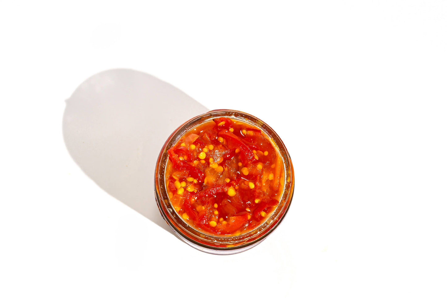 Jar of red sauce on a white background