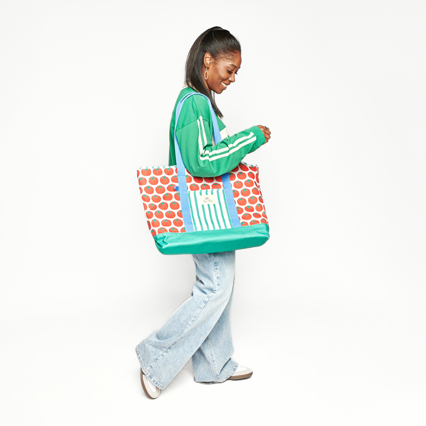 Woman holding a colorful tote bag with a white background